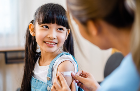Child receiving vaccine from public health nurse